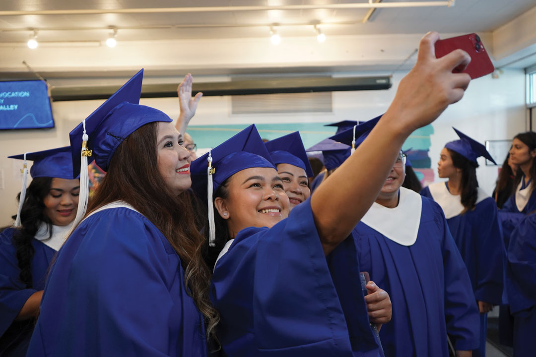 A group of NIC graduates take a selfie while in regalia backstage at the 2025 convocation ceremony.