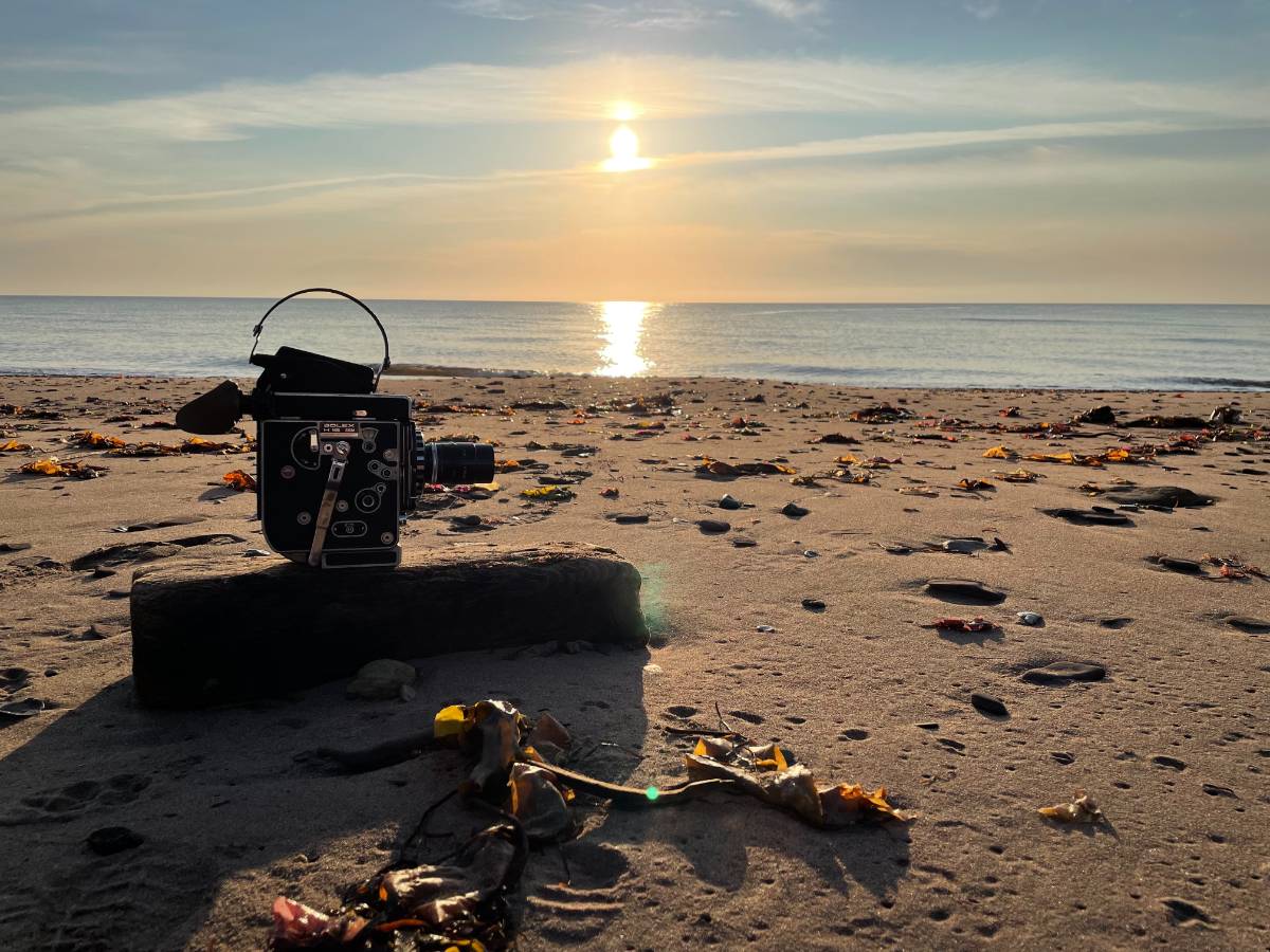 16mm camera sitting on the beach looking at the sunrise