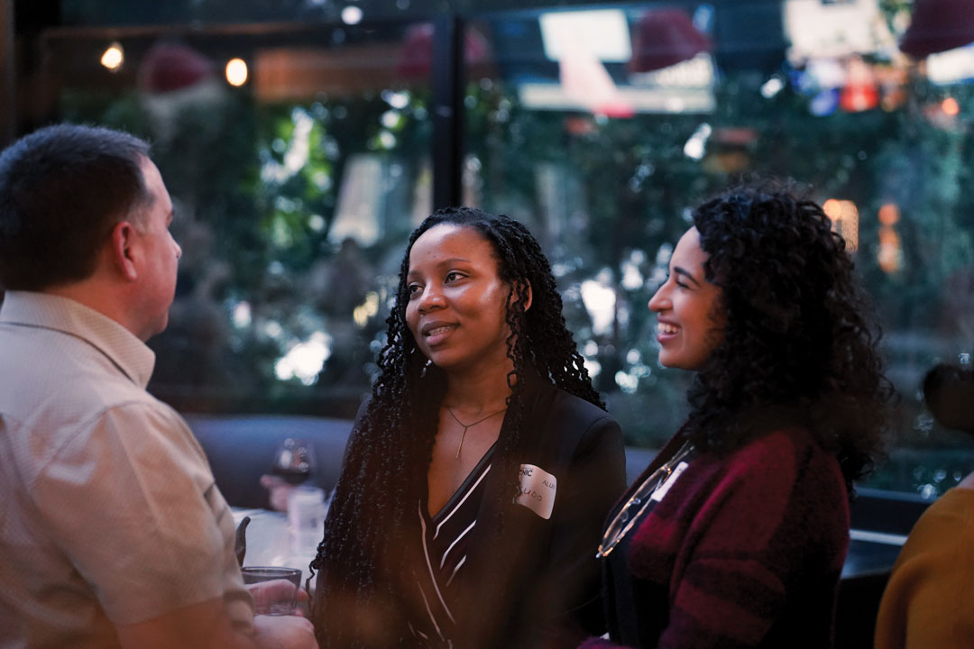 Two alumni share a conversation at the 2025 alumni mixer.