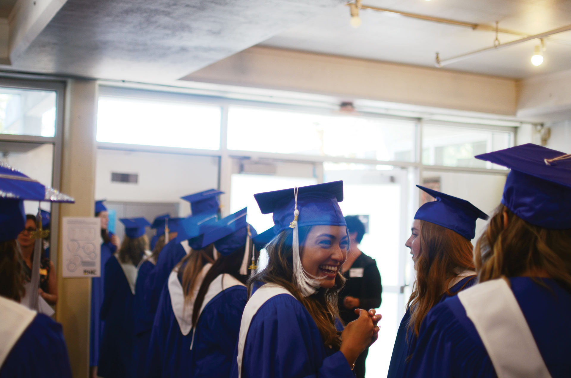 students in regalia gathering in lobby at convocation