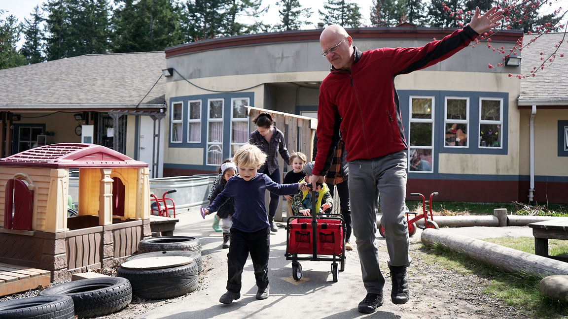 An early childhood educator student guides a youngster through play