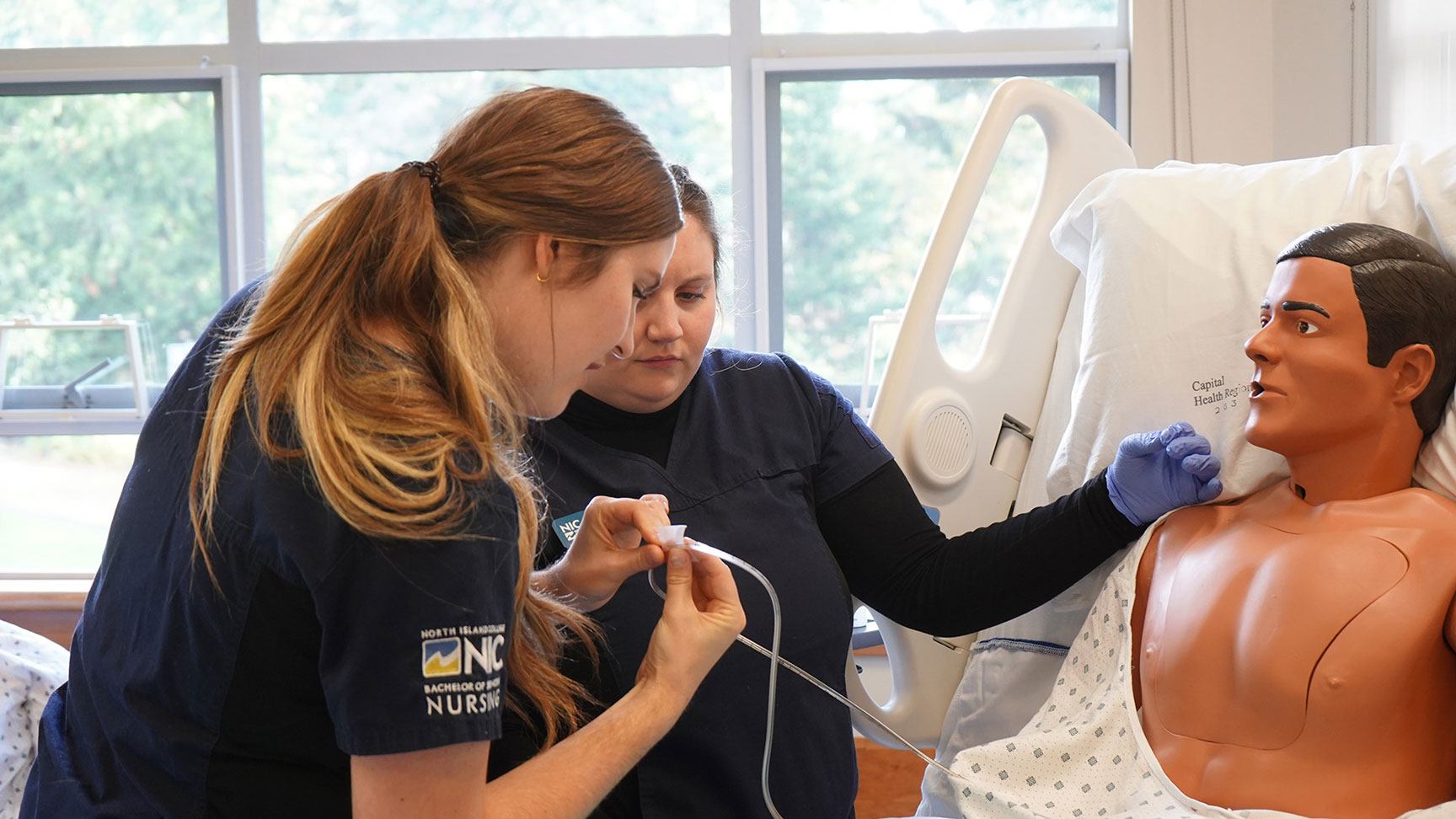 nursing students practise on a mannequin.