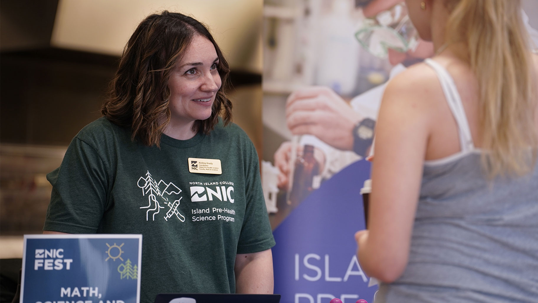A faculty member talks to a potential student at an information fair