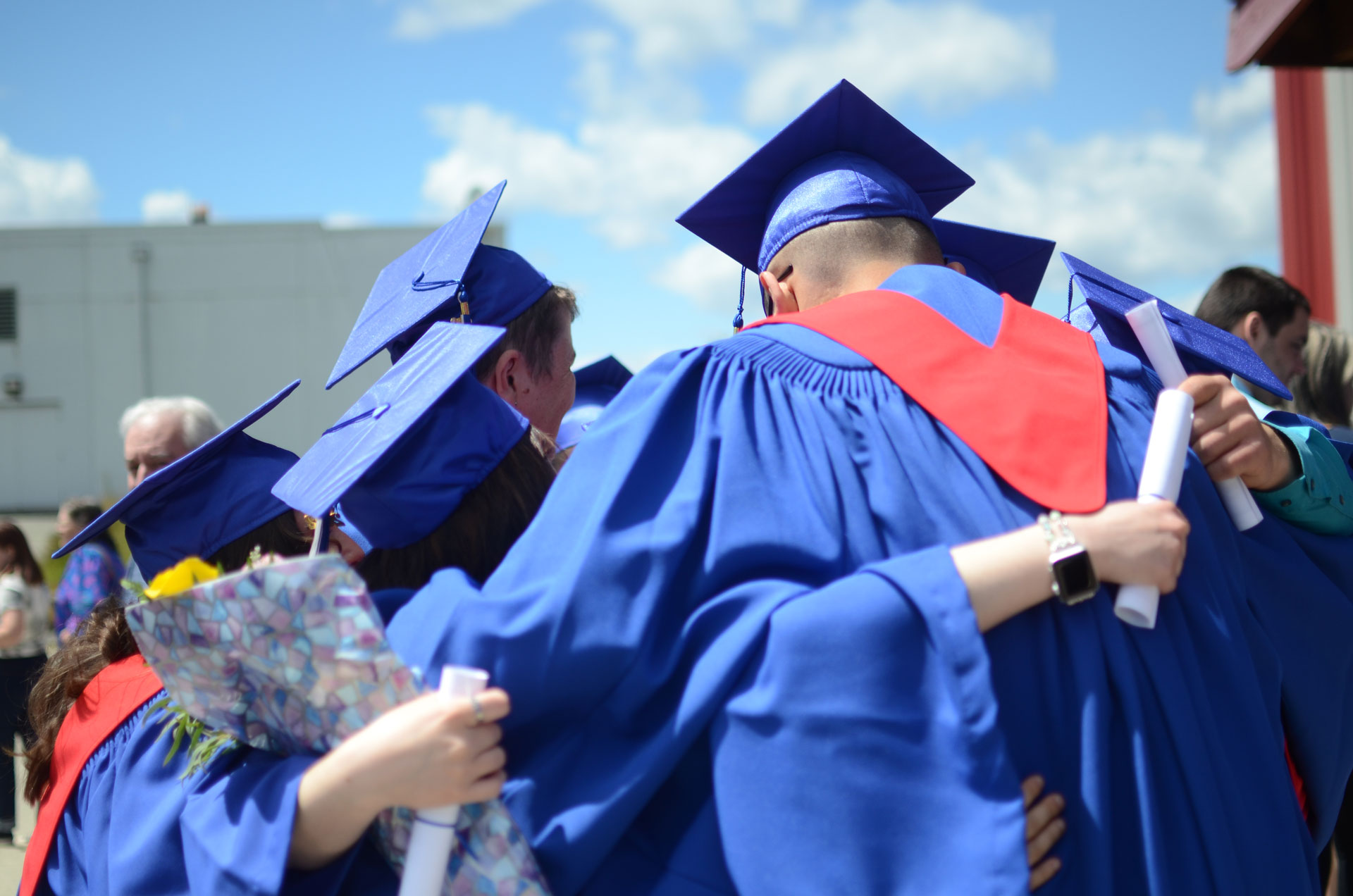 A group of graduates from Accessible Education programs embrace outside their convocation celebration