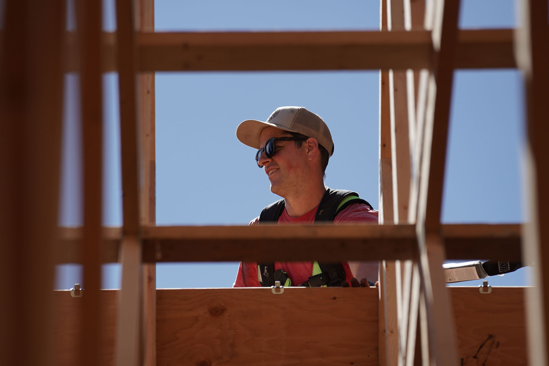 NIC Carpentry alum stands on a roof of a construction project