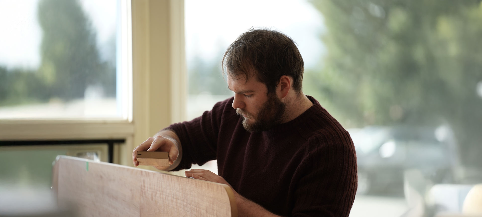 NIC Joinery student sanding a table top at the Port Alberni Furniture Design and Joinery workshop