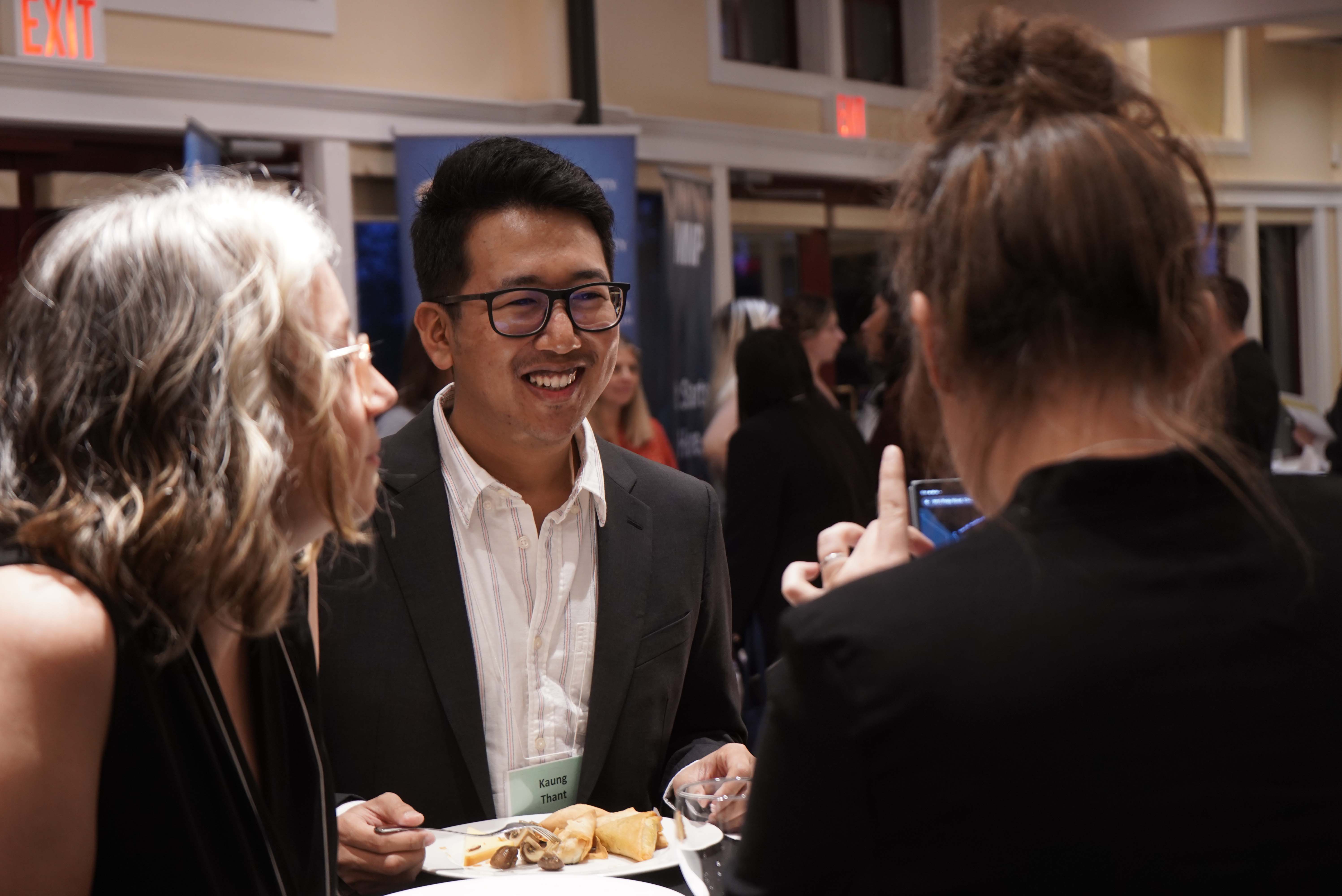Smiling student engaging with employers at networking evening event